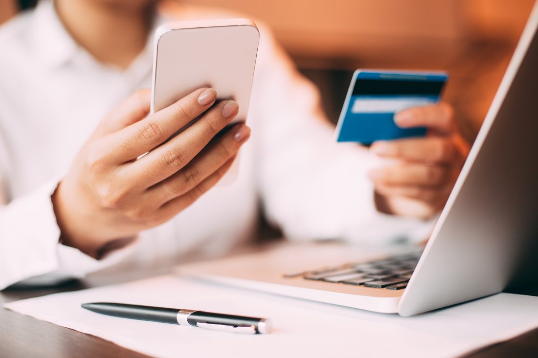 a person shopping online at Ebates, with their credit card and phone out. 