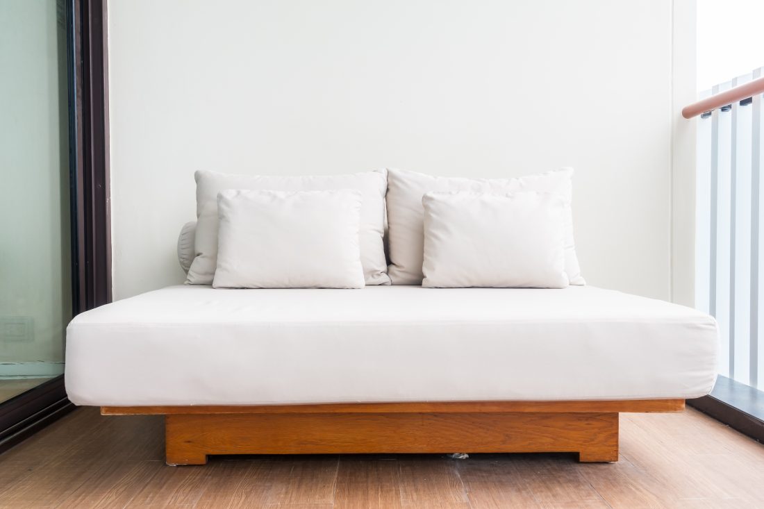 Picture of a bed on a porch - renting a house is a great way to make money while you travel. 