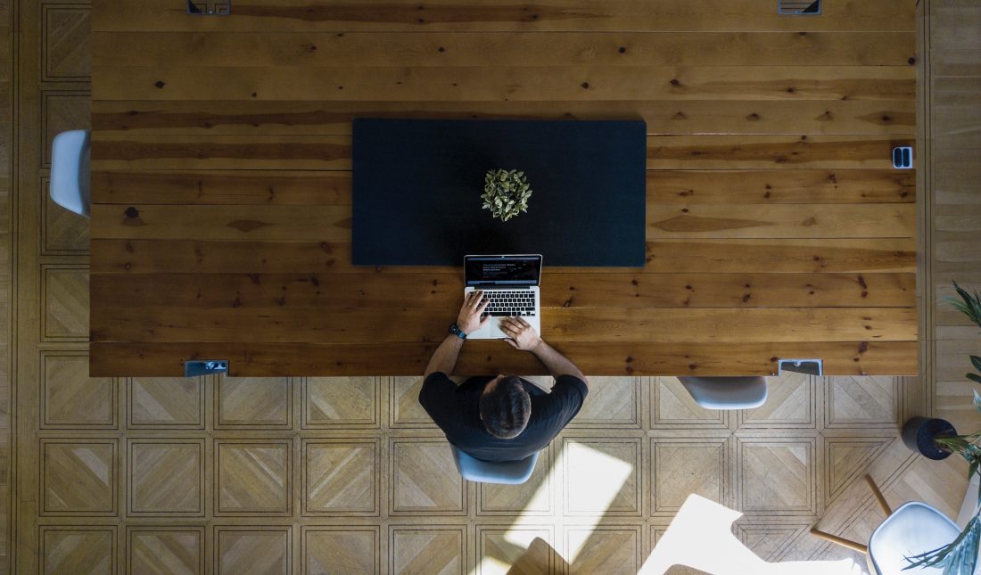 Picture of a a person working at a laptop on a computer designing a website